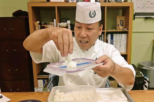 Chef Andy shows his test results in his Sushi Chef Institute (SCI) office.