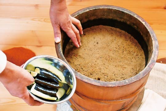 Eggplants are about to be embedded in the fermented rice bran bed. 