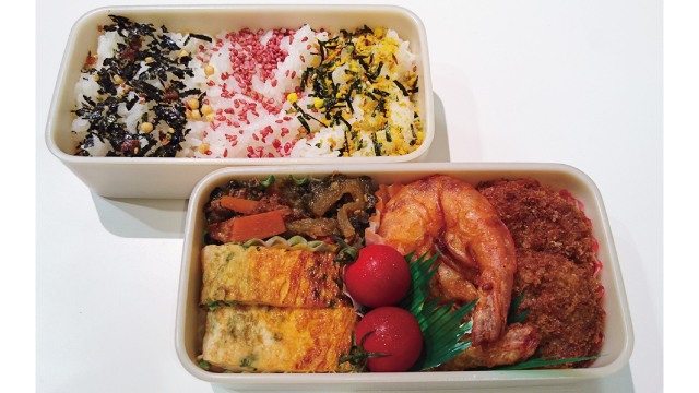 Three popular types of furikake in Japan are lined up in a bento box. From left to right: seaweed and bonito, plum, and a mix of seaweed, egg, and sesame.